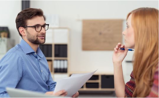 Personaldisponent und Zeitarbeitsbeschäftigte in der Zeitarbeitsniederlassung im Gespräch