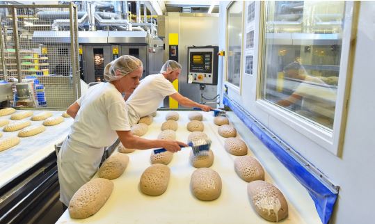 Zwei Beschäftigte arbeiten in einem Backbetrieb