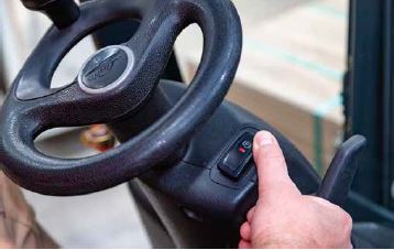 Abb. 23 Vor Verlassen des Flurfrderzeugs Feststellbremse anziehen und Gabeln absenken. Auf geneigten Flchen zustzlich durch Unterlegkeile das Wegrollen verhindern.